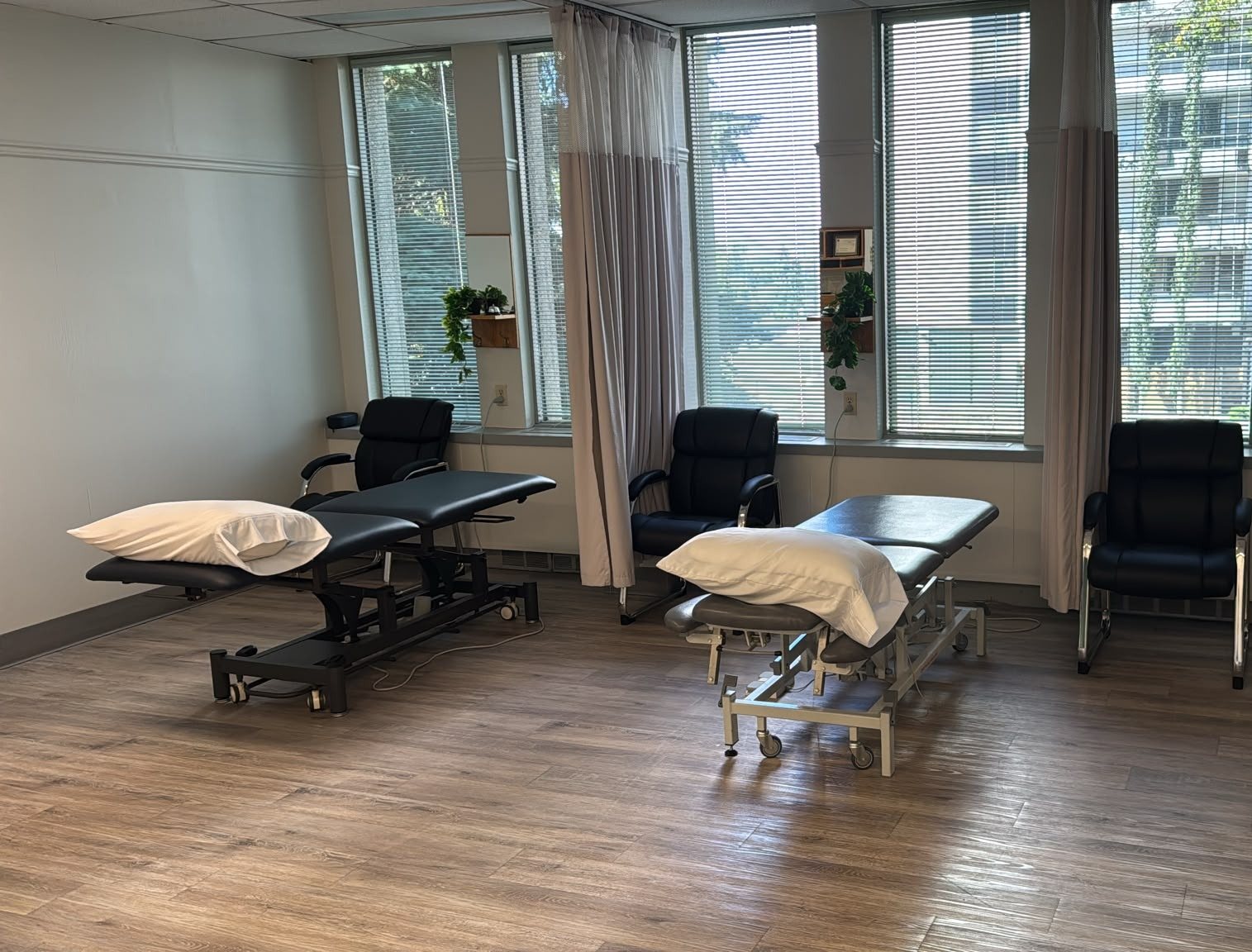 Treatment area at Aura Physiotherapy with padded treatment tables beside large windows